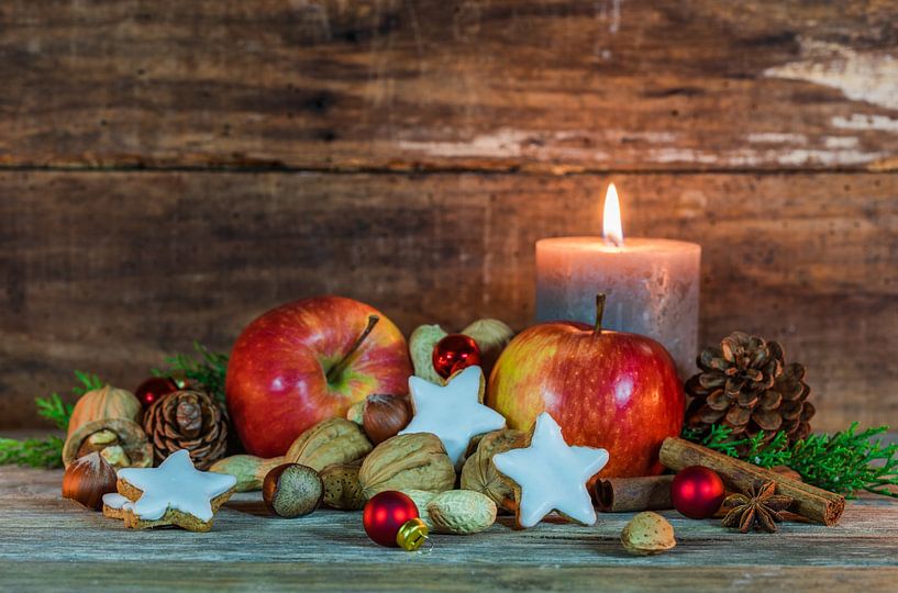 Weihnachtsdekoration mit Lebensmitteln und brennende Kerze auf dem Tisch mit rustikalen hölzernen Hi von Alex Winter