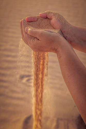 Sand, der durch die Finger rinnt
