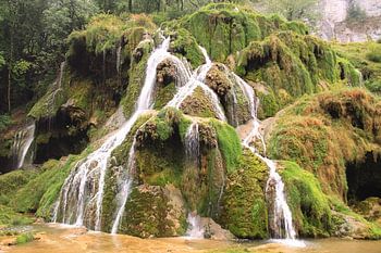 Wasserfall über grünen Felsen in der Natur