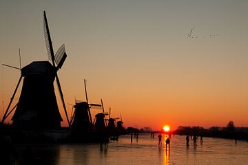 Met zonsopkomst op de schaats bij Kinderdijk van Leander Janssen