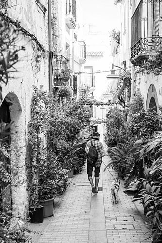 Wandelaar met hond in de smalle straatjes van Javea