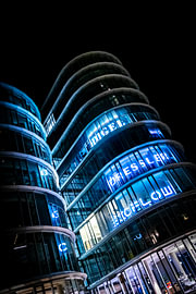 In coolem blauem Neonlicht beleuchtetes modernes Gebäude im Düsseldorfer Medienhafen von Your Happy Life