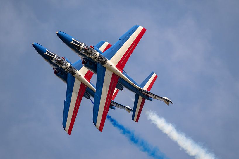 Two aircraft of the Patrouille Acrobatique de France (PAF) in action during the La Ferté-Alais Airsh by Jaap van den Berg