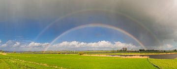 Regenboog tijdens een regen- en hagelbui boven de IJssel.