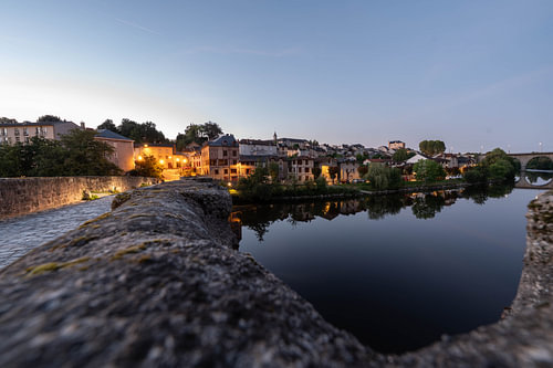 De oude binnenstad van Riverside bij schemering, met een stenen muur en rustig water, Frankrijk