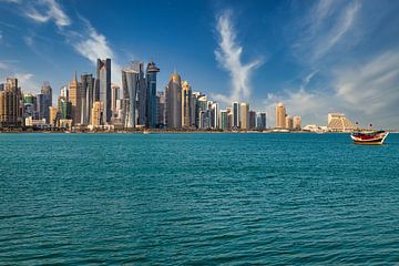 Vue de l'horizon de Doha depuis la promenade de la corniche en après-midi, montrant des boutres avec