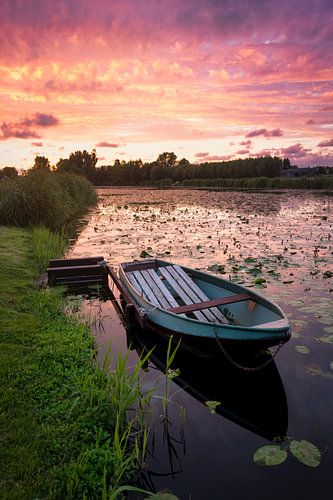 Oude roeiboot in de vaart tijdens zonsondergang