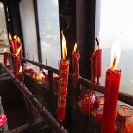 Burning red candles in Chinese Buddhist temple by Ger Beekes