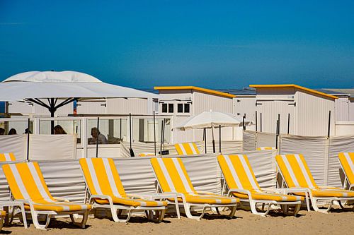 Ligstoelen bij strandhuisjes