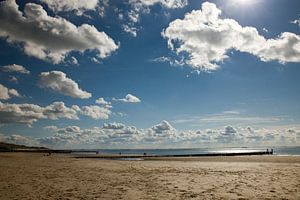 Witte wolken blauwe lucht aan het strand