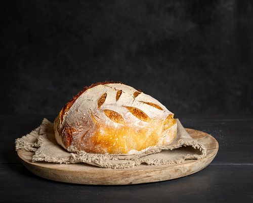 Traditioneel zuurdesembrood op een ronde plank met servet.