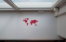 Zerbrechliche Erde. Weltkarte, ausgeschnitten aus rotem Papier, auf der Fensterbank von Irene Cecile