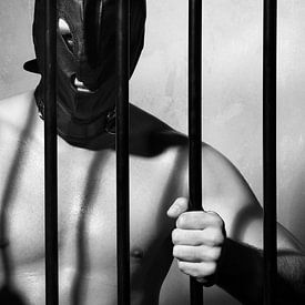 Man behind prison bars in submissive fetish style by Photostudioholland