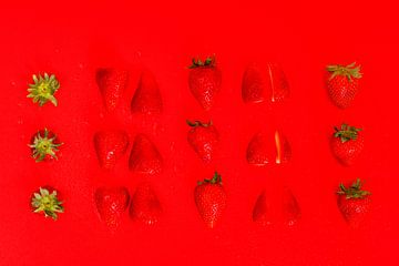 In Scheiben geschnittene Erdbeeren auf rotem Hintergrund von Wim Stolwerk