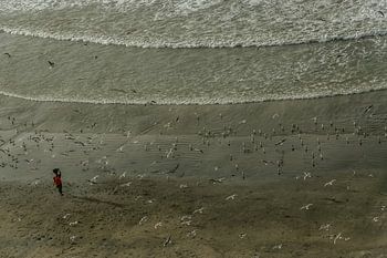 Een eenzame vissersvrouw op het strand