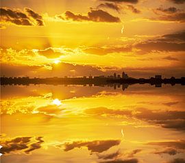 Skyline Amsterdam met ondergaande zon. van Brian Morgan