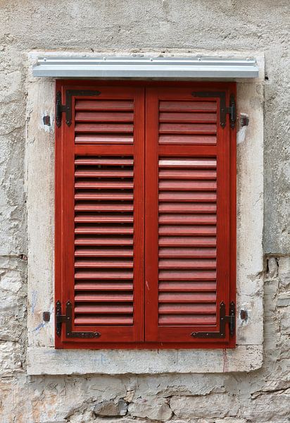 rote Fensterläden eines Fensters in der historischen Altstadt von Pula in Kroatien von Heiko Kueverling