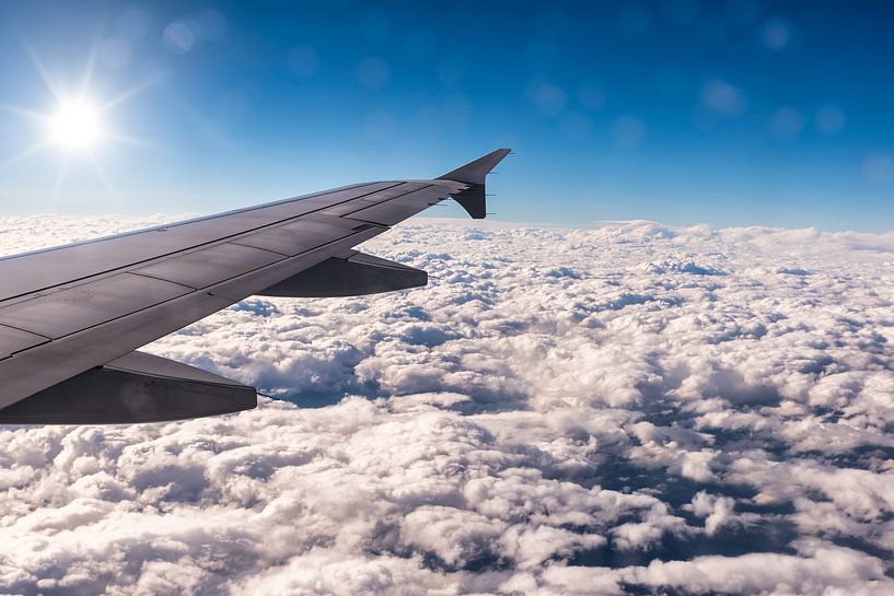 Airplane wings with sun above the clouds by Dieter Walther