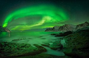 Aurora over Ersfjord and Tugeneset rocky coast with mountains in background, Norway