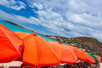 Perspectief op rode paraplu's op het zonnige strand van Yevgen Belich