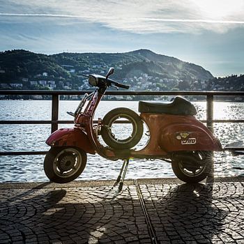 Vespa tegen een ondergaande zon aan het comomeer