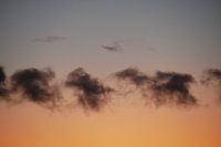 Kleine rij wolken in de zonsondergang