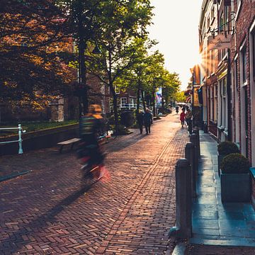 Cyclist going through Delft with sunset