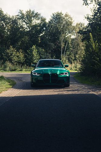 Groene BMW M3 G80 in een rustgevende, bosrijke omgeving