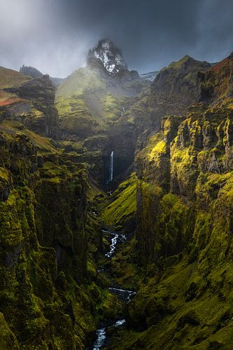Een mooie groene kloof met waterval in Ijsland.