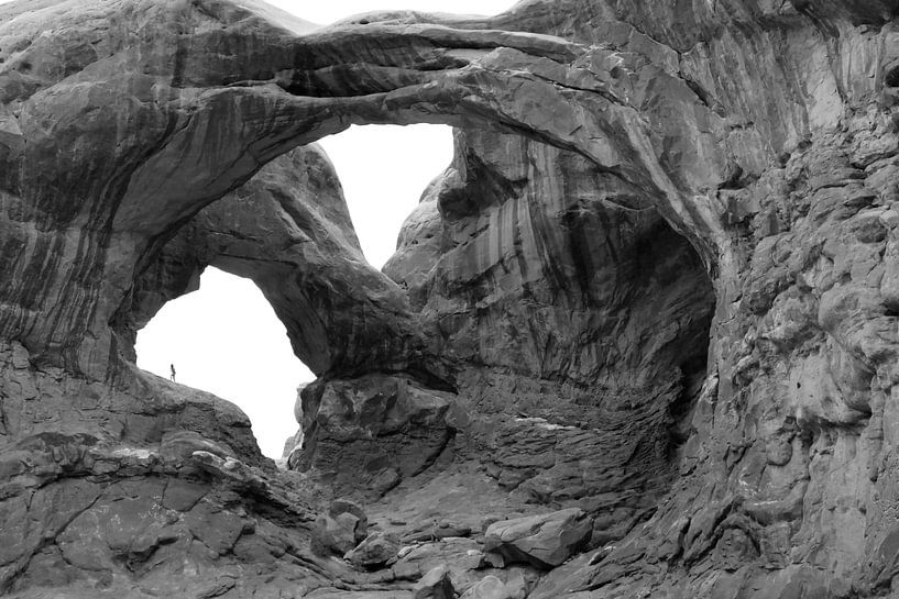 kleine figuur in de rotsbogen in zwart-wit in Arches National Park van Jonathan Vandevoorde