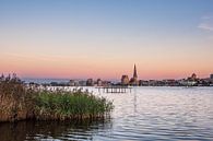 Uitzicht over de Warnow naar de Hanzestad Rostock in de avond van Rico Ködder thumbnail