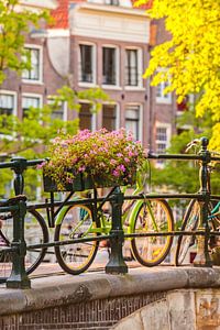 Fietsen op een gracht in Amsterdam van Martin Bergsma