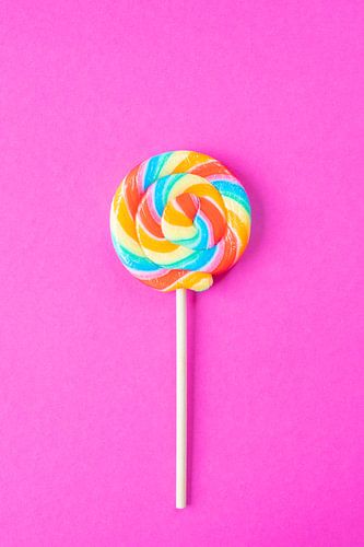 Rainbow colours on a lollipop on a bright pink background art print