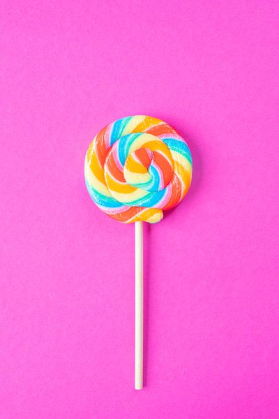 Rainbow colours on a lollipop on a bright pink background art print by Christa Stroo photography