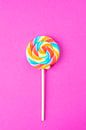 Rainbow colours on a lollipop on a bright pink background art print by Christa Stroo photography thumbnail