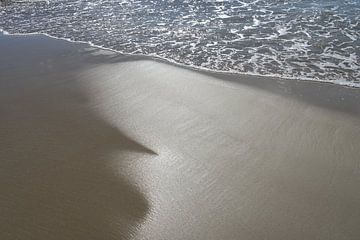 Nat zand en zeewater in zonlicht 1