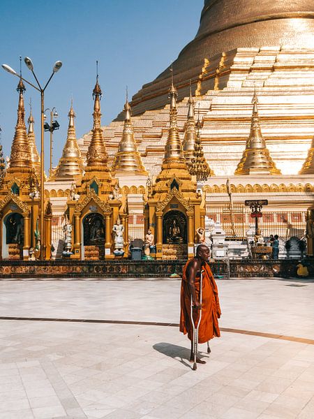 Boeddhistische monnik met krukken bij de gouden Shwedagon Pagoda (Pagode) Yangon (Rangoon), Myanmar van Michiel Dros