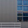 Horizontalen en verticalen - een foto van een gevel op een industrieterrein van Cobi de Jong