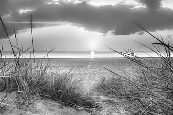 Sonnenaufgang am Strand an der Ostsee in schwarz-weiß