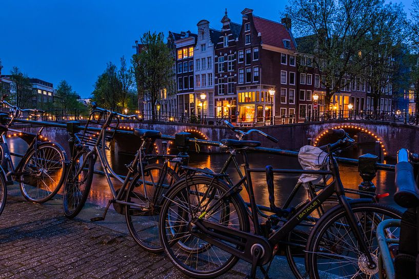Bridge over the prinsengracht in Amsterdam at night by John Ouds