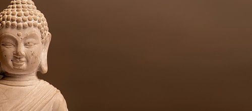 Buddha bust in front of a dark background