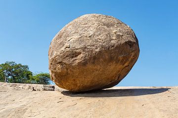 A giant round boulder stands on a hillside against a blue sky. by WorldWidePhotoWeb