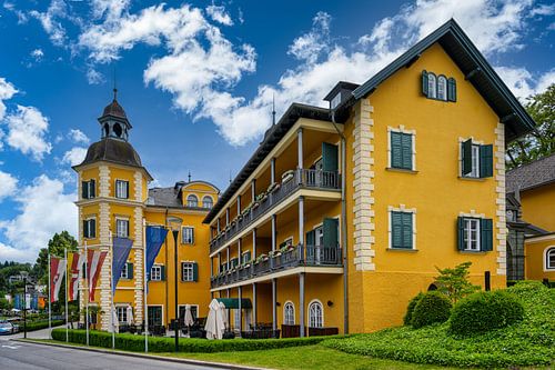 Uitzicht op een kasteel aan het prachtige meer van Woerthersee