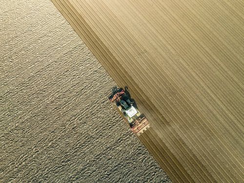 Tractor maakt de grond klaar voor het planten van gewassen