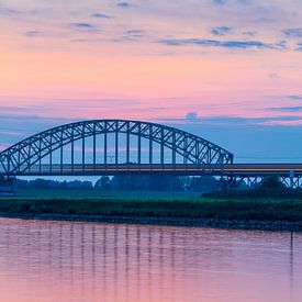 Trein op Spoorbrug na zonsondergang van Thijs Vermeer