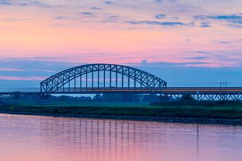 Train sur le pont de chemin de fer après le coucher du soleil