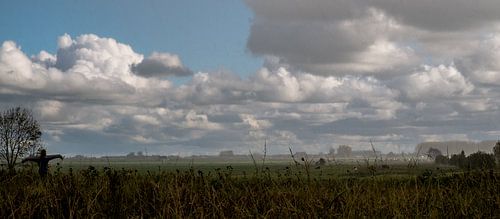 landscape with scarecrow in rain and sun