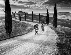 Schwarz-weißes Kunstfoto von Radfahrern, die auf den legendären Schotterstraßen Strade Bianche in der Toskana, Italien, fahren
