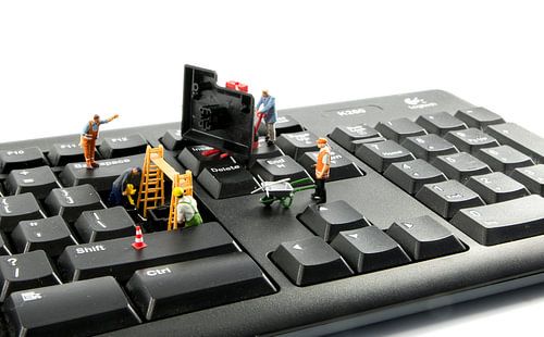 little world figures repairing the key board of the computer or try to hack or intergate in the syst
