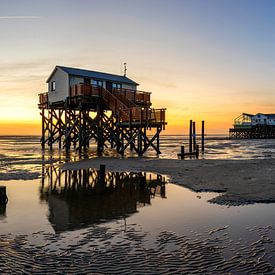 Pile dwellings on the North Sea coast on the beach at St. Peter Ording at sunset by Frank Herrmann